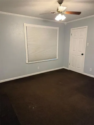 an empty room with a ceiling fan and a window