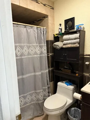 a bathroom with a toilet and a shower curtain