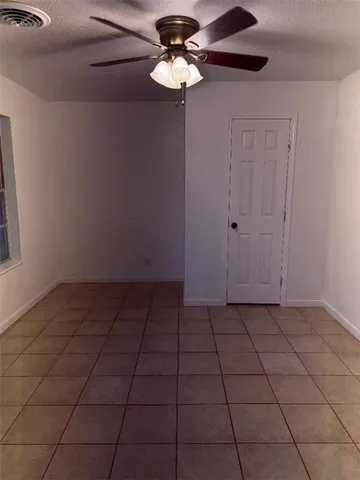 a view of a chandelier fan in an empty room