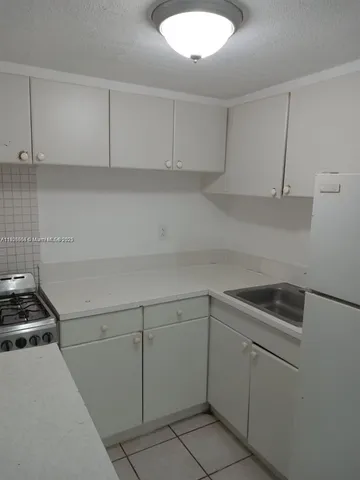 a kitchen with white cabinets and a sink