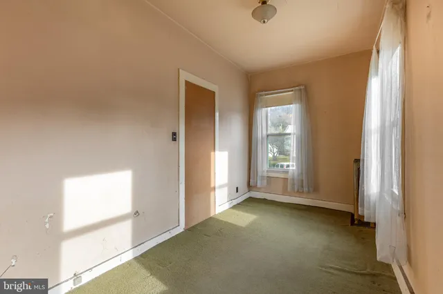a view of an empty room with wooden stairs