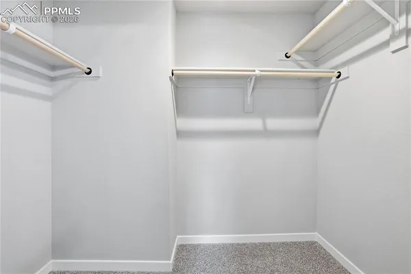 a view of walk in closet with clothes