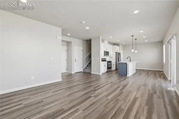 a view of empty room with wooden floor