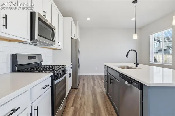 a kitchen with stainless steel appliances granite countertop a sink stove and microwave