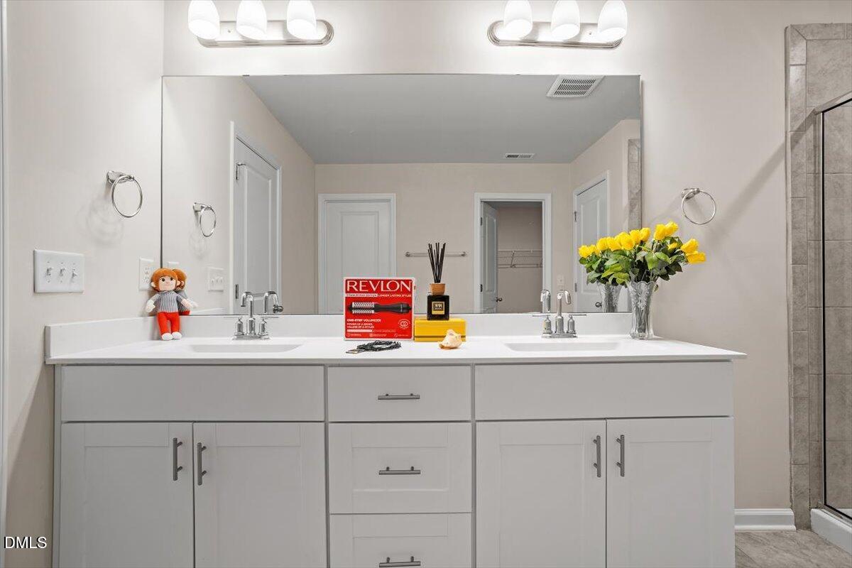46 Coffee Tree Circle Clayton, NC 27527 - Photo 24 of 36 a bathroom with a sink and a mirror