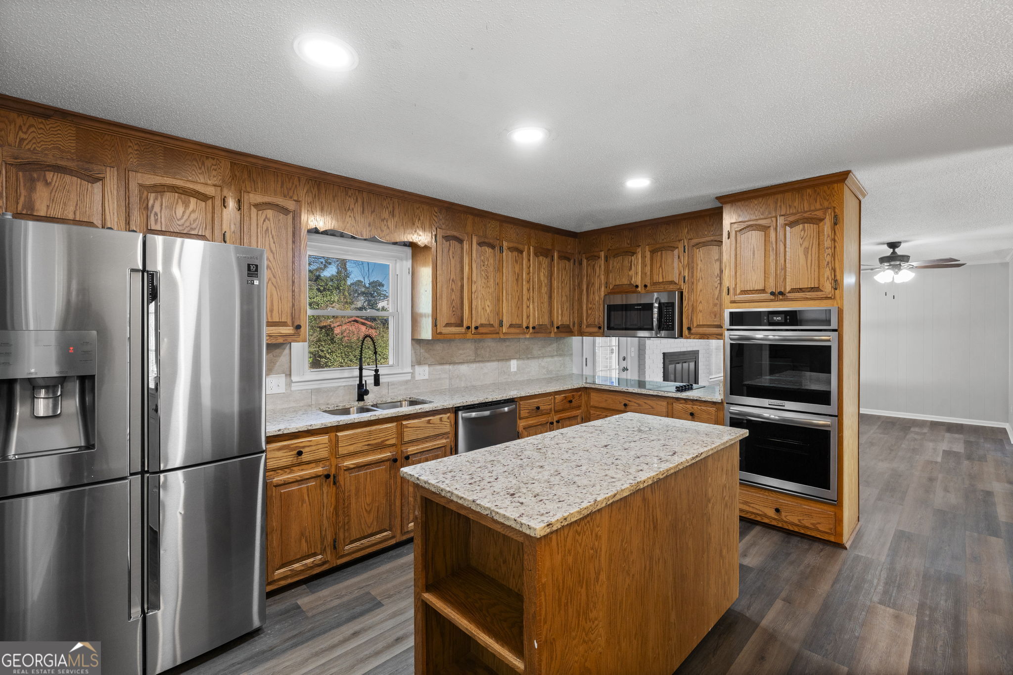 1729 Milton Way Perry, GA 31069 - Photo 12 of 41 a kitchen with stainless steel appliances granite countertop a refrigerator a stove top oven a sink and dishwasher with wooden floor
