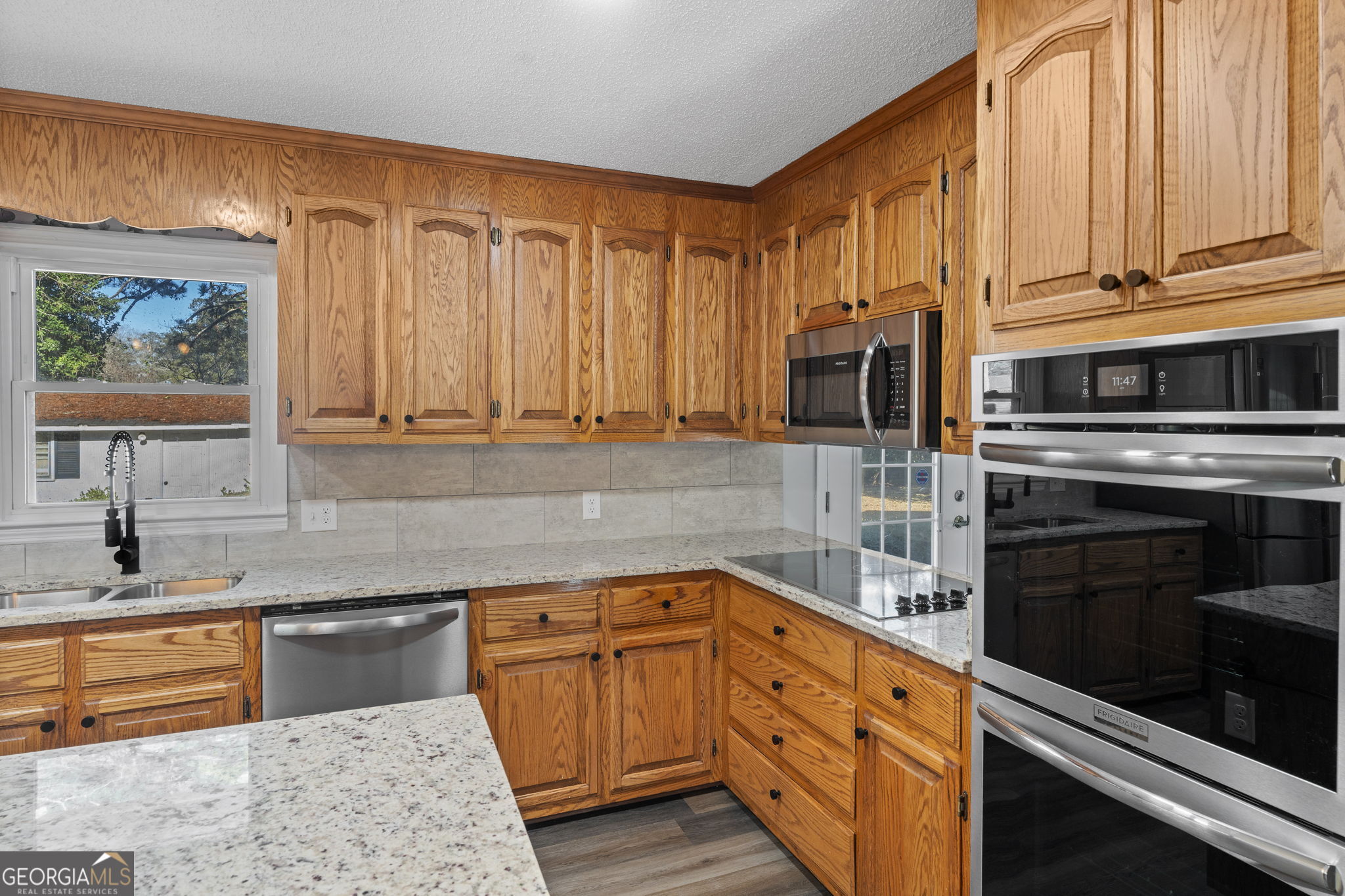 1729 Milton Way Perry, GA 31069 - Photo 14 of 41 a kitchen with stainless steel appliances granite countertop a stove a sink and a microwave