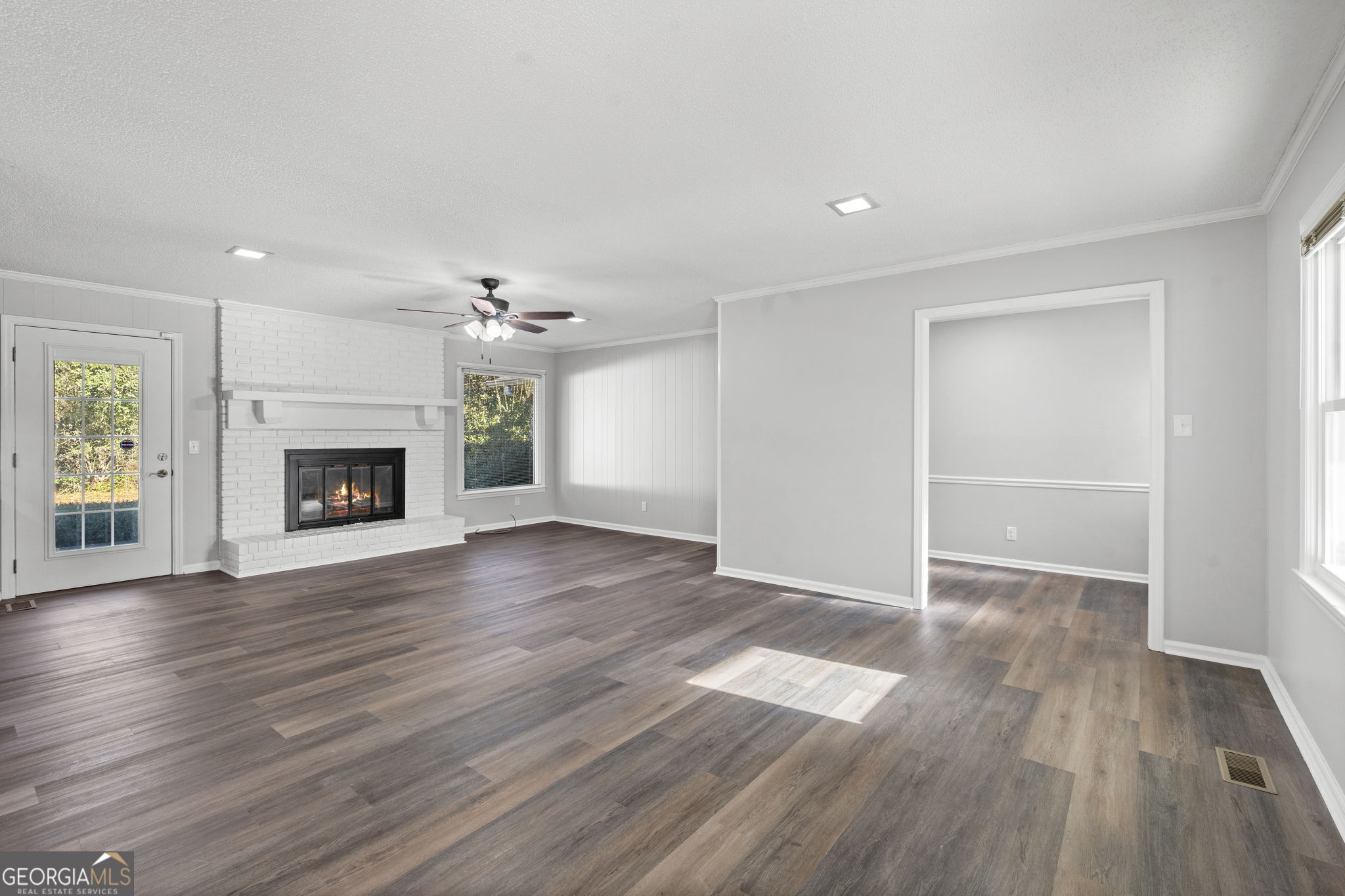 1729 Milton Way Perry, GA 31069 - Photo 7 of 41 an empty room with wooden floor fireplace and windows