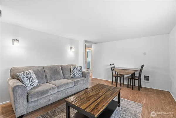 a living room with furniture a dining table and a piano table with wooden floor