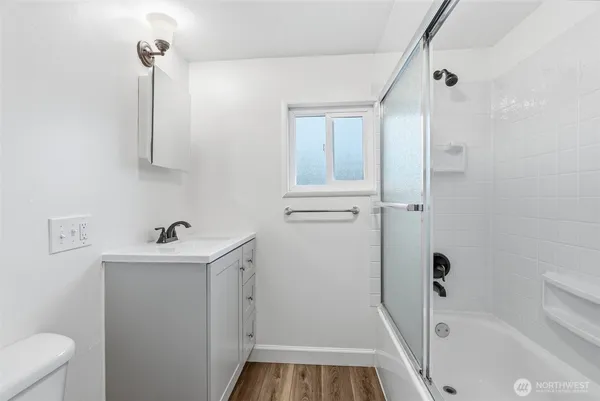 a bathroom with a sink a toilet and shower