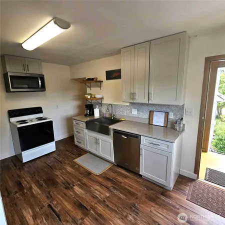 a kitchen with stainless steel appliances granite countertop a stove a sink and a microwave