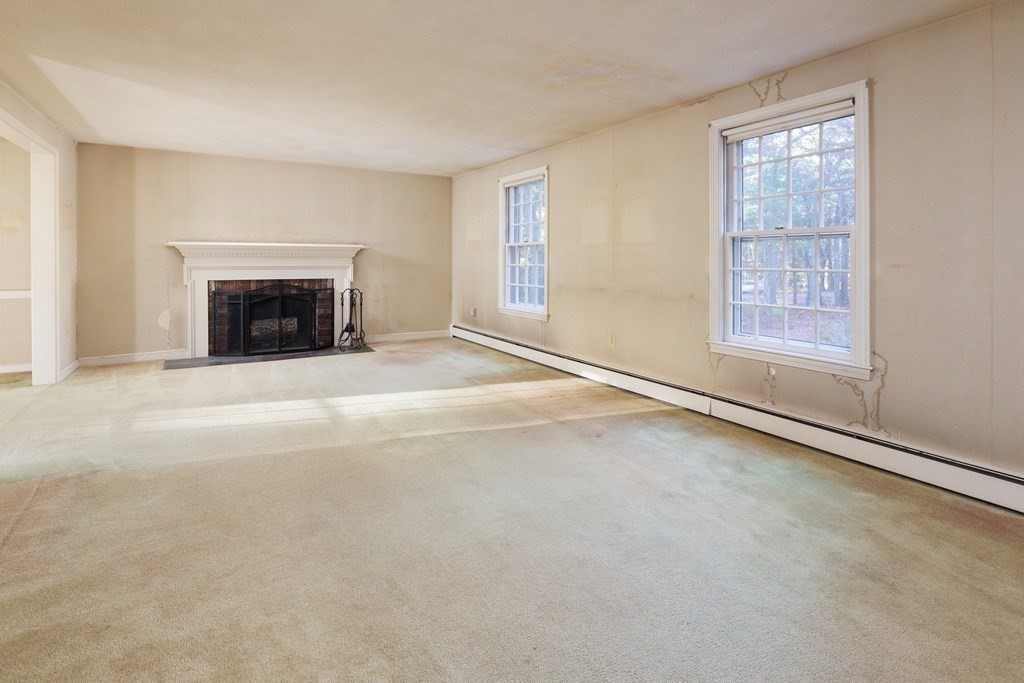 555 Heald Road Carlisle, MA 01741 - Photo 4 of 22 an empty room with windows and fireplace