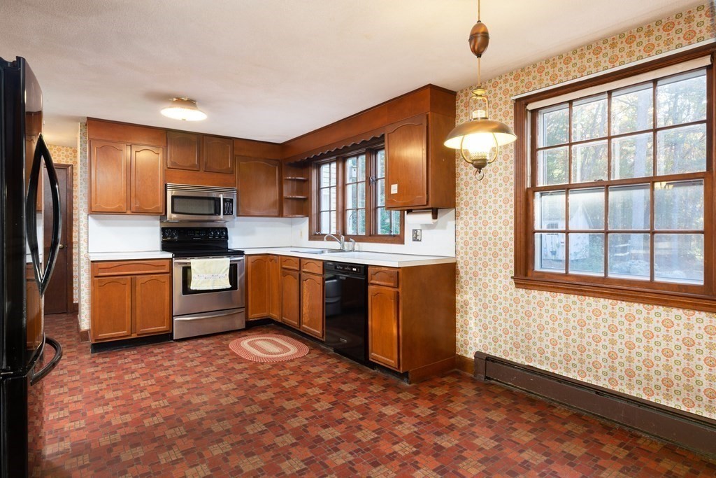 555 Heald Road Carlisle, MA 01741 - Photo 7 of 22 a kitchen with granite countertop a stove a sink and a refrigerator