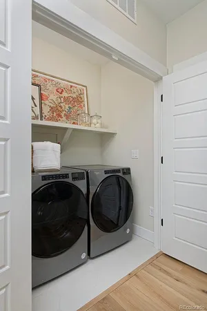 a utility room with wooden floor washer and dryer