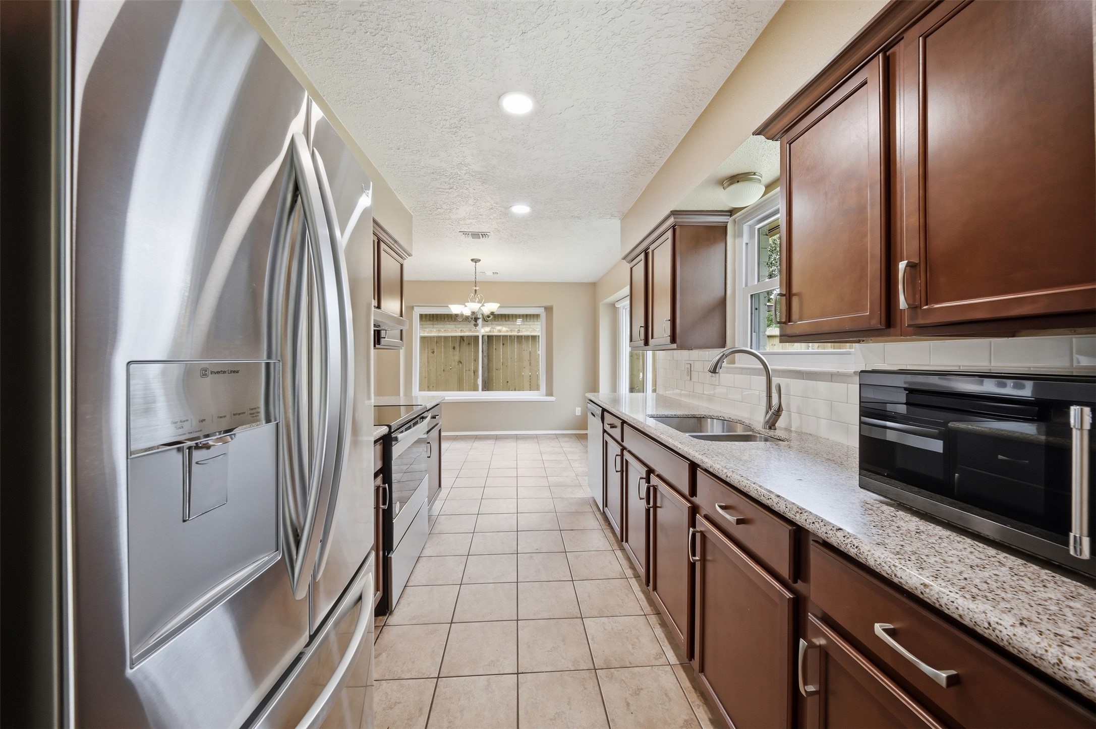 9418 Kilrenny Drive Spring, TX 77379 - Photo 24 of 47 a kitchen with stainless steel appliances granite countertop a refrigerator and a sink
