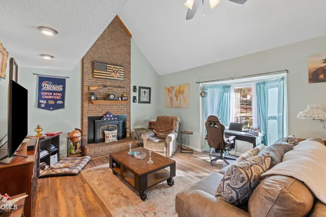 a living room with furniture a flat screen tv and a fireplace
