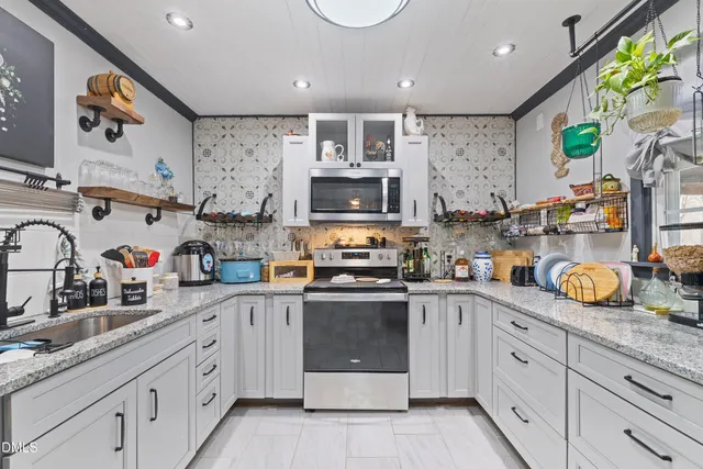 a kitchen with kitchen island granite countertop a sink stainless steel appliances and cabinets