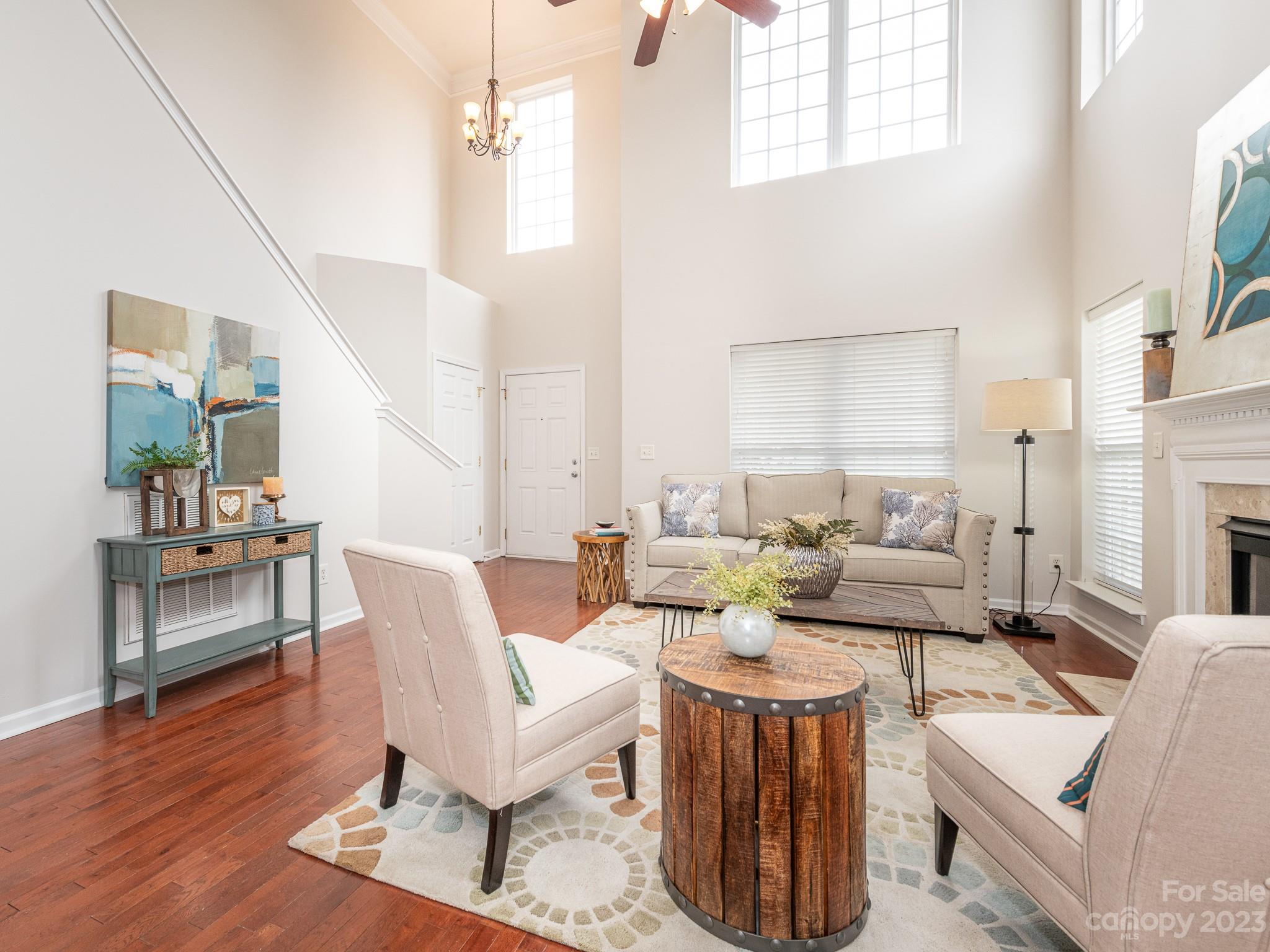 3764 Leela Palace Way Fort Mill, SC 29708 - Photo 4 of 32 a living room with furniture a wooden floor and a chandelier