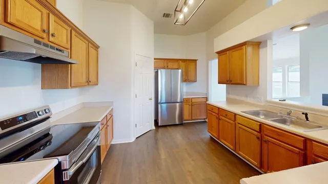 a kitchen with stainless steel appliances a sink and wooden cabinets