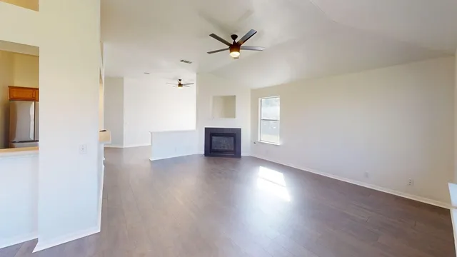 a view of a livingroom with wooden floor and a ceiling fan