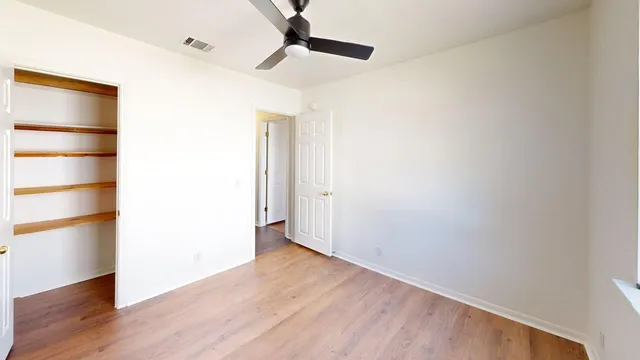 a view of an empty room with wooden floor