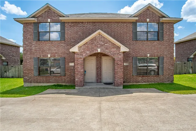 a front view of a house with a garden and yard