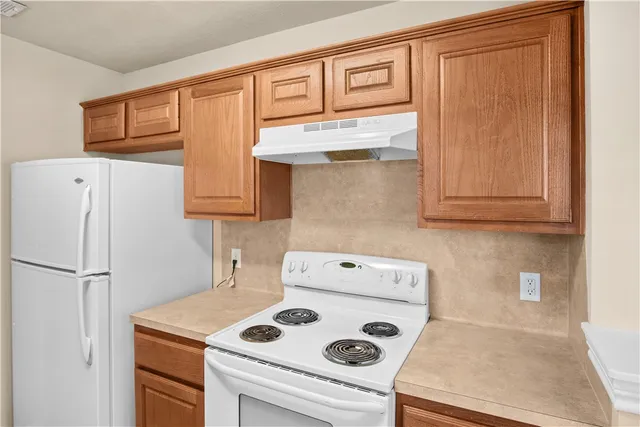 a kitchen with stainless steel appliances granite countertop cabinets and a refrigerator