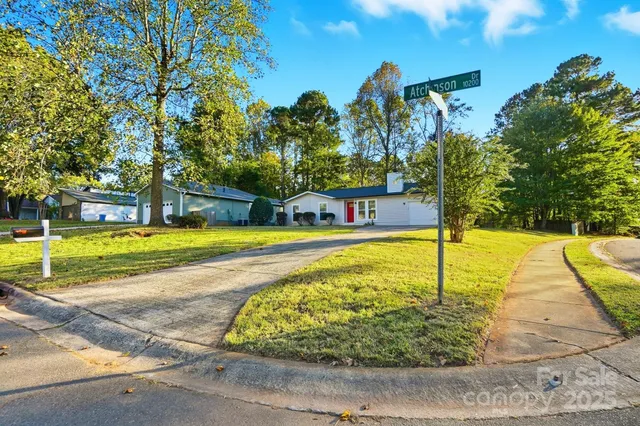an empty room with chandelier fan and windows