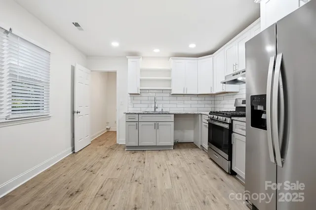 a kitchen with stainless steel appliances a refrigerator sink and cabinets
