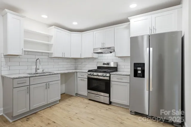 a kitchen with a stove a refrigerator and a sink