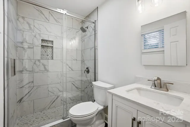an empty room with wooden floor ceiling fan and windows