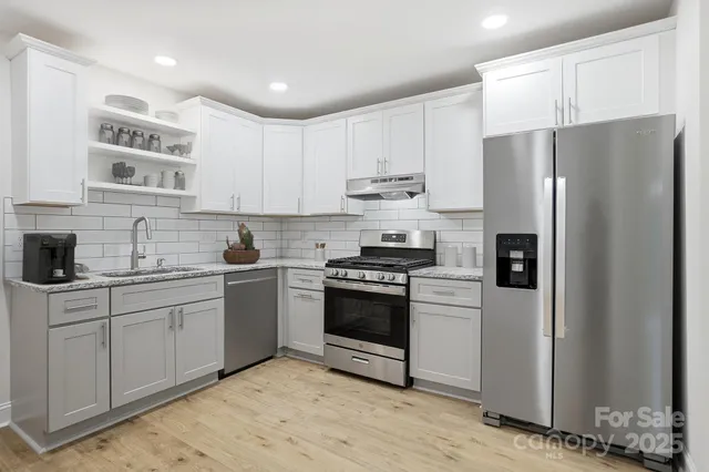a kitchen with a refrigerator and a stove top oven