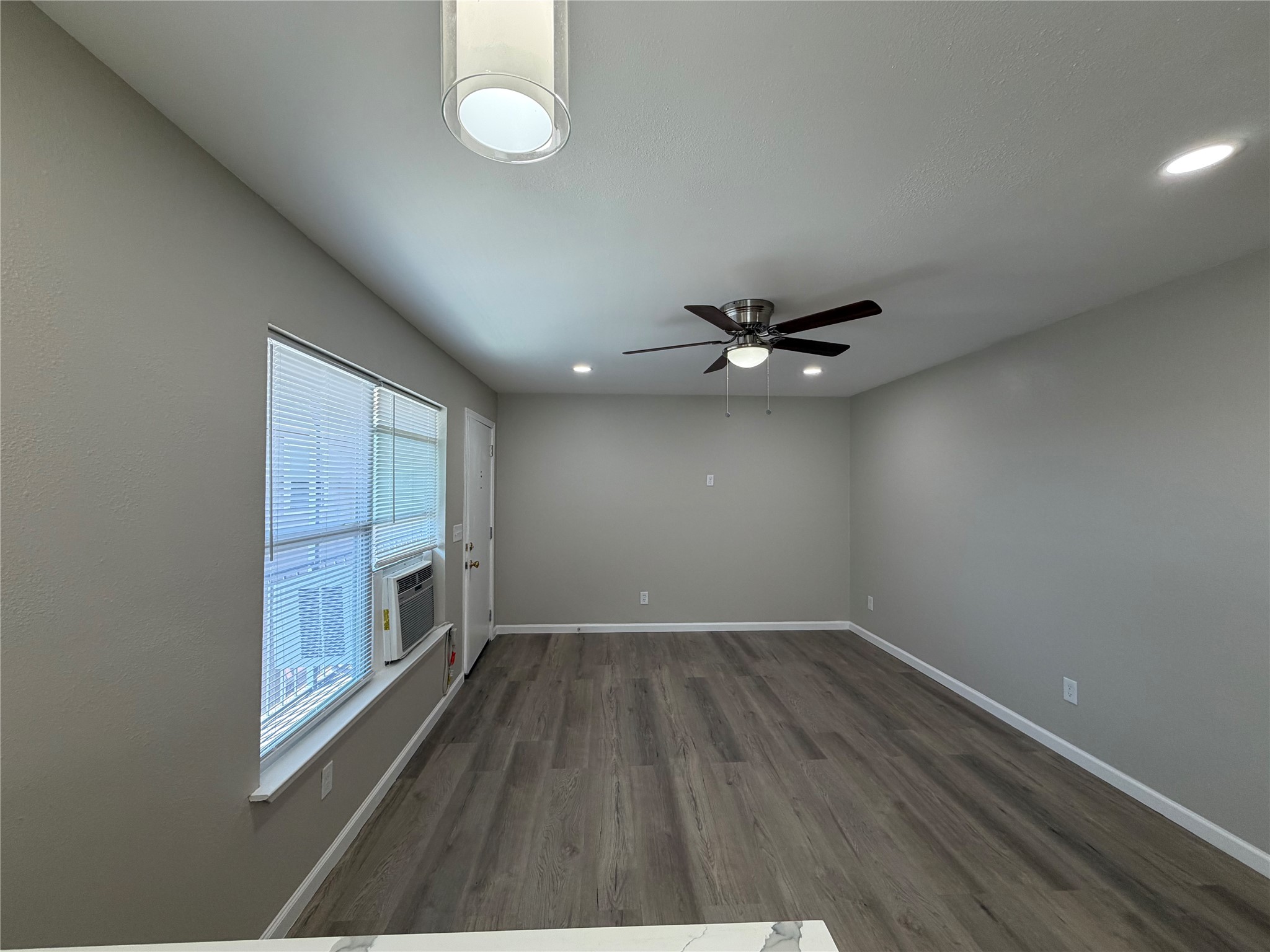 3113 Arbor Street, Unit 4 Houston, TX 77004 - Photo 3 of 11 an empty room with wooden floor fan and windows