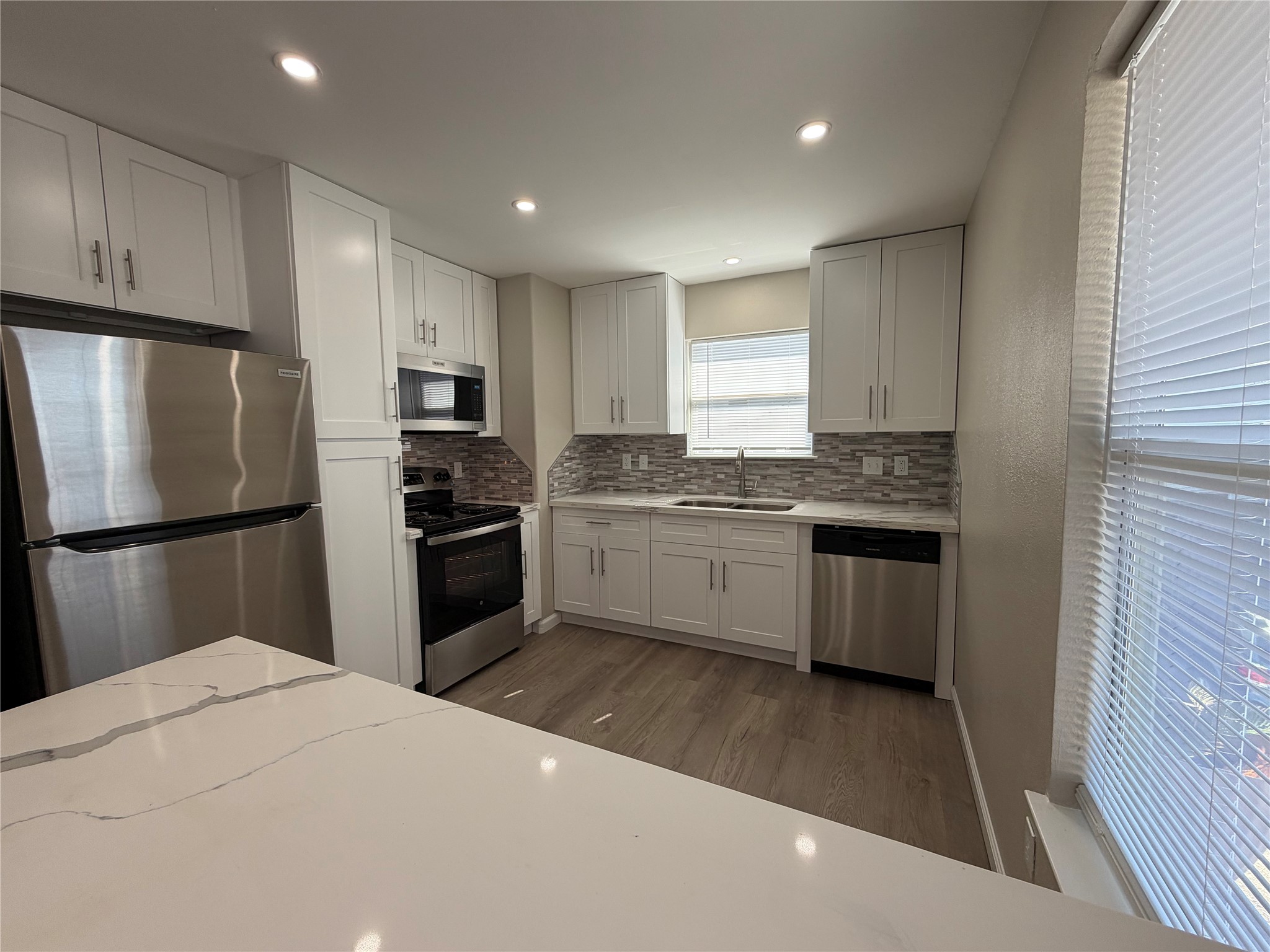 3113 Arbor Street, Unit 4 Houston, TX 77004 - Photo 4 of 11 a kitchen with kitchen island a refrigerator sink and cabinets