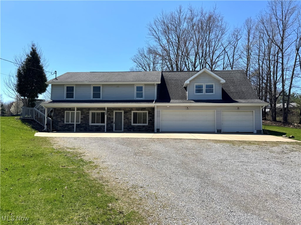 8961 Herbert Road Canfield, OH 44406 - Photo 1 of 26 Traditional home featuring an attached garage, driveway, stone siding, and a front lawn