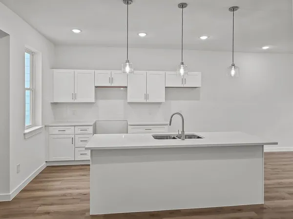 a kitchen with kitchen island white cabinets and stainless steel appliances