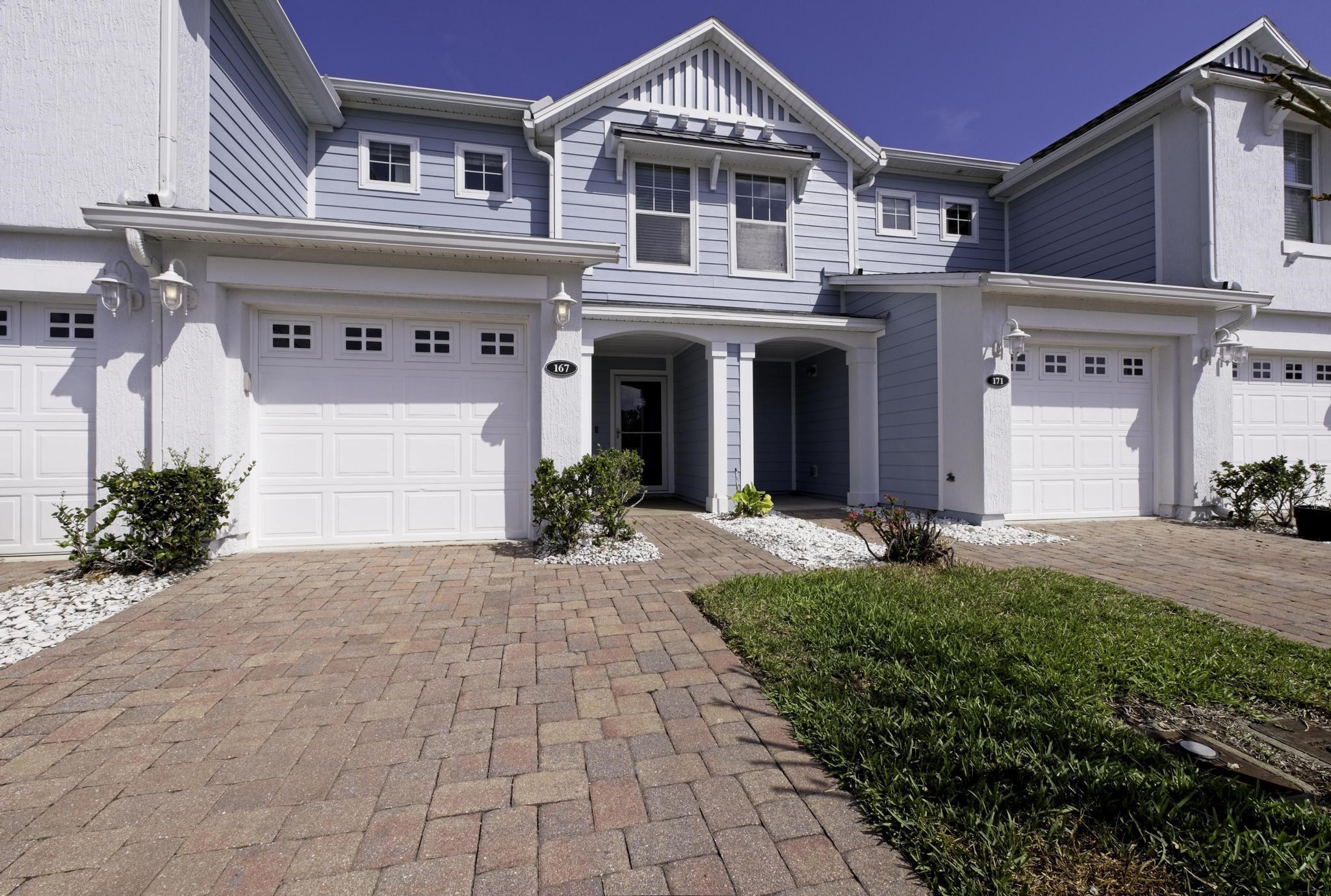 a front view of a house with yard and potted plants