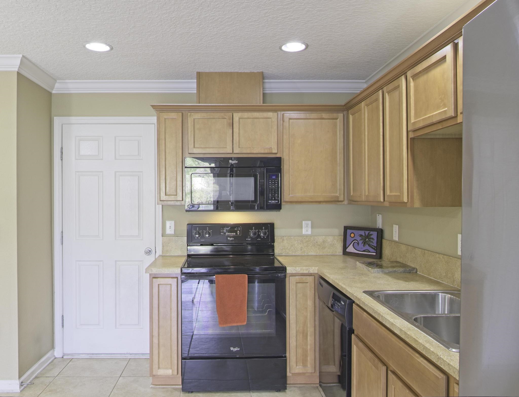 167 Islander Drive St. Augustine, FL 32080 - Photo 11 of 34 a kitchen with granite countertop a stove a sink and a refrigerator