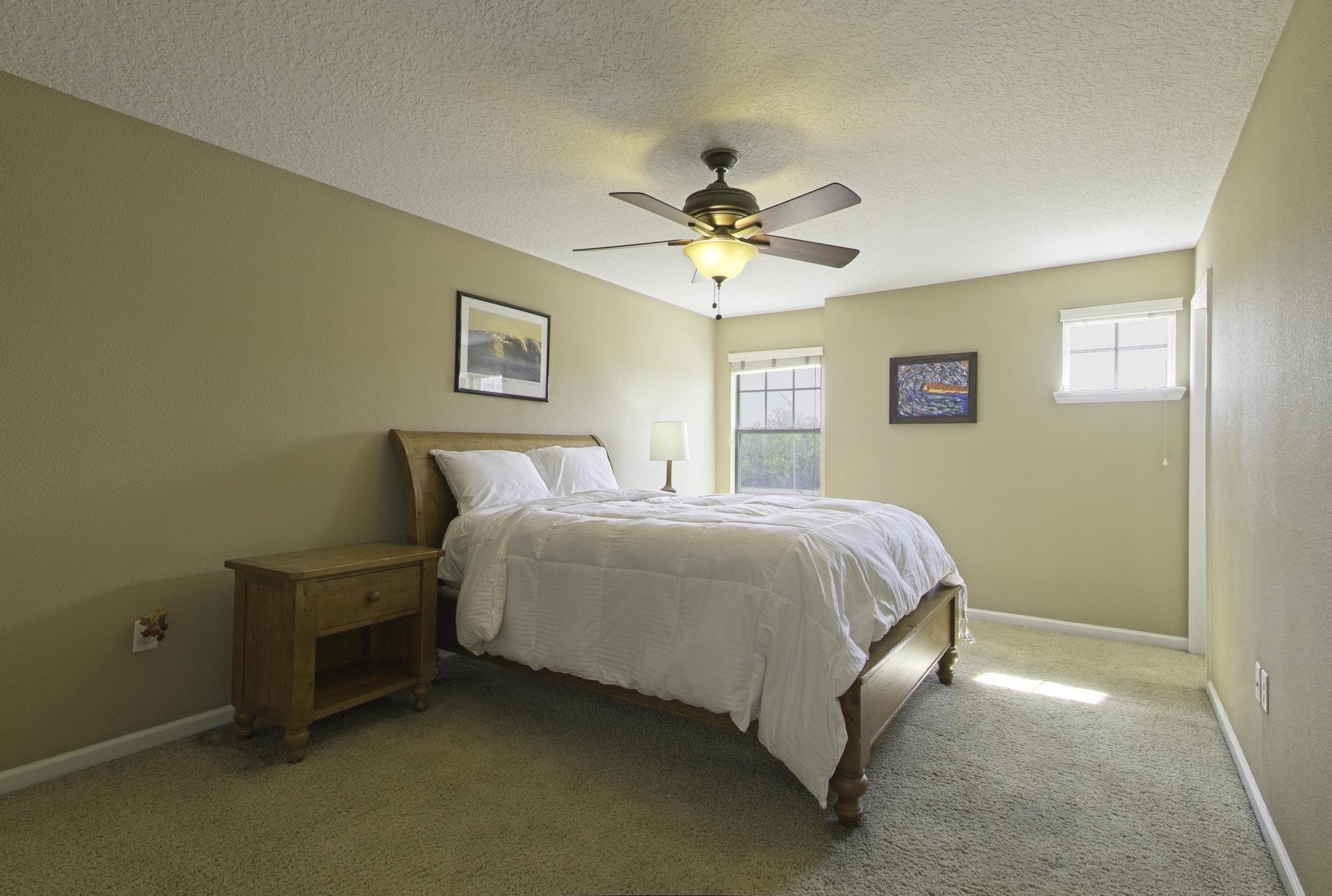 167 Islander Drive St. Augustine, FL 32080 - Photo 12 of 34 a spacious bedroom with a bed and a chandelier
