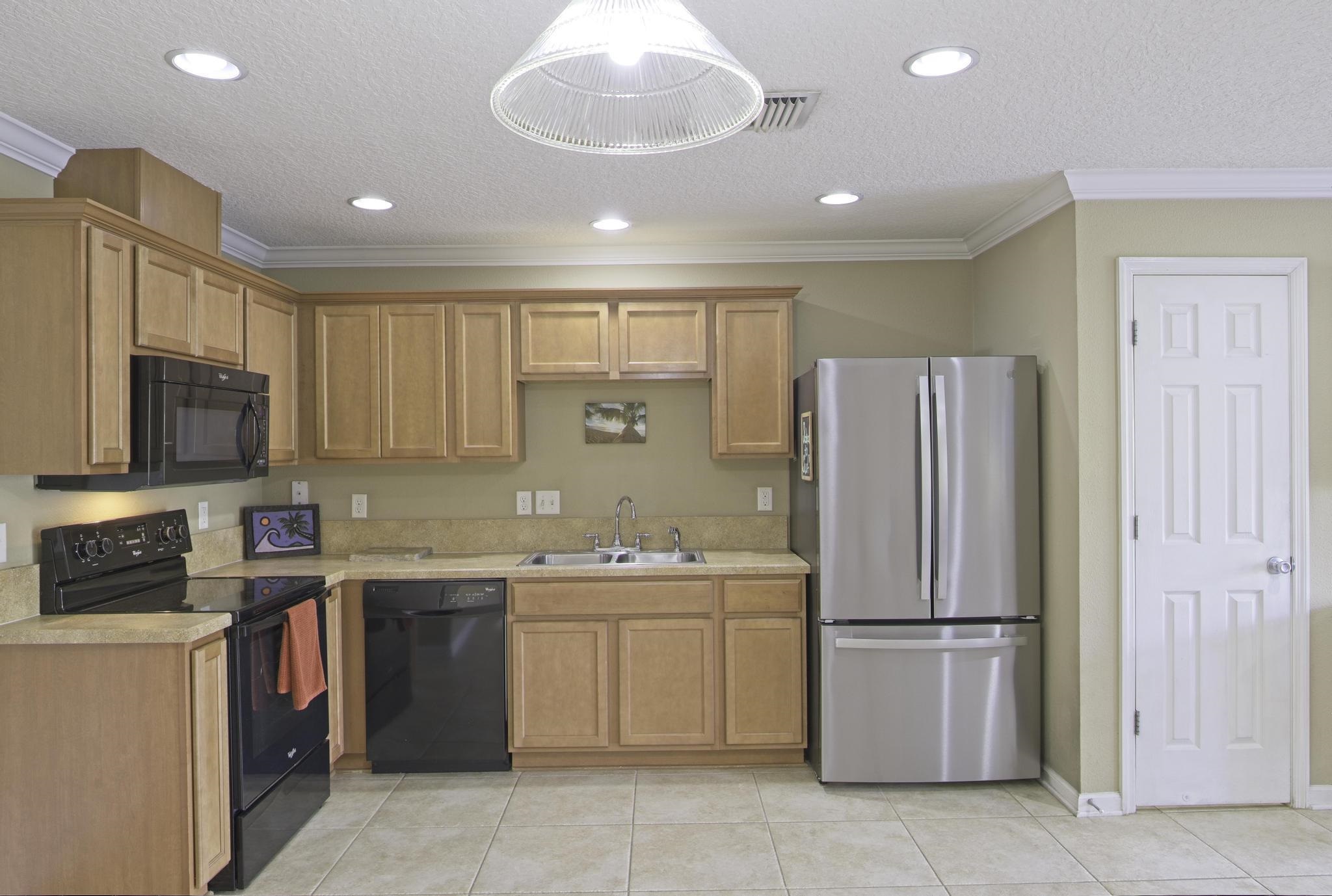 167 Islander Drive St. Augustine, FL 32080 - Photo 10 of 34 a kitchen with a sink a refrigerator and cabinets
