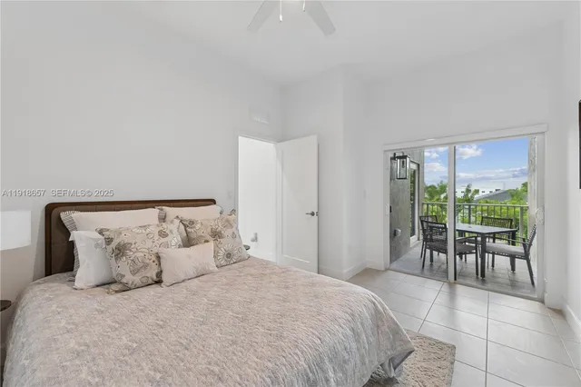 a large bed sitting in a bedroom next to a window with table and chair