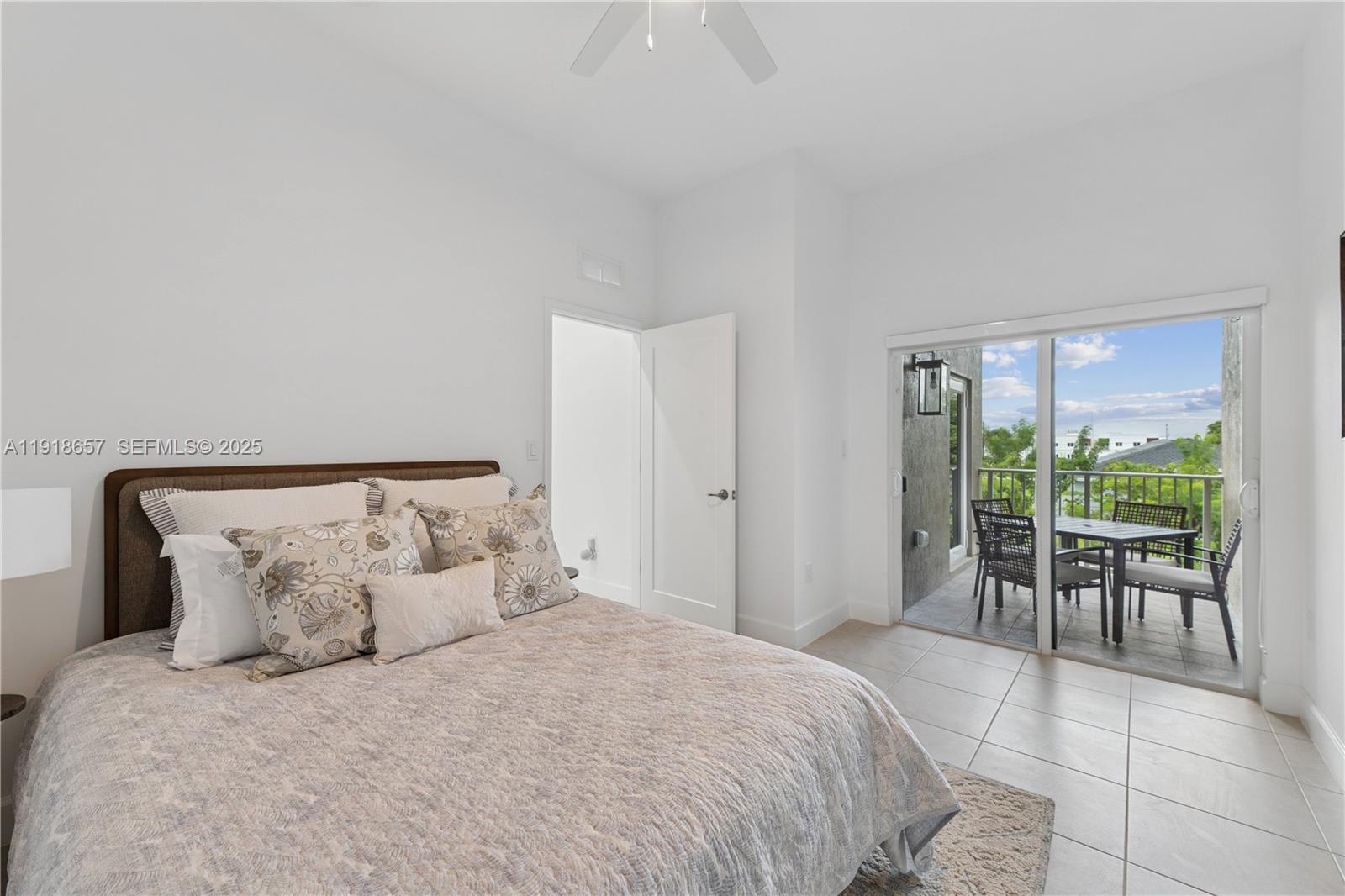 a large bed sitting in a bedroom next to a window with table and chair