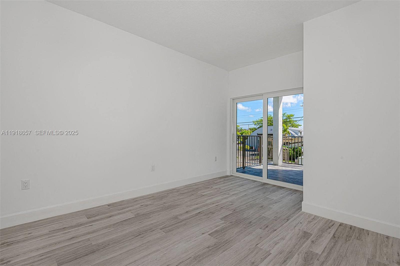355 Northwest 30th Avenue, Unit 1311 Pompano Beach, FL 33069 - Photo 2 of 19 an empty room with wooden floor and windows