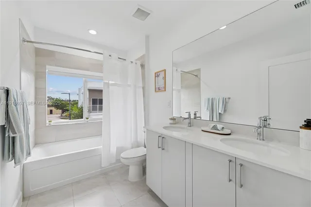 a bathroom with a granite countertop sink mirror bathtub and toilet