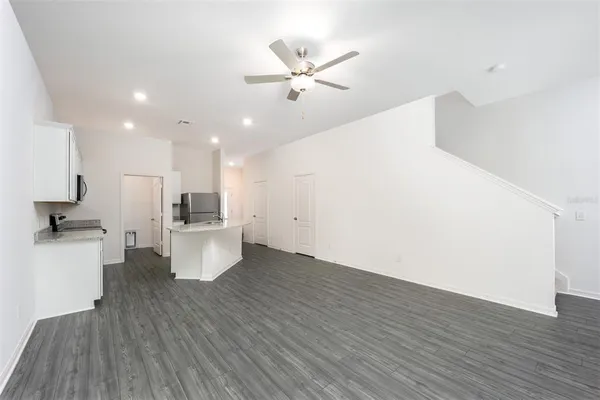 a view of kitchen with cabinets stainless steel appliances and wooden floor