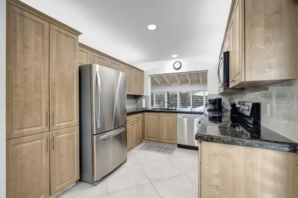 a kitchen with granite countertop a refrigerator and a sink