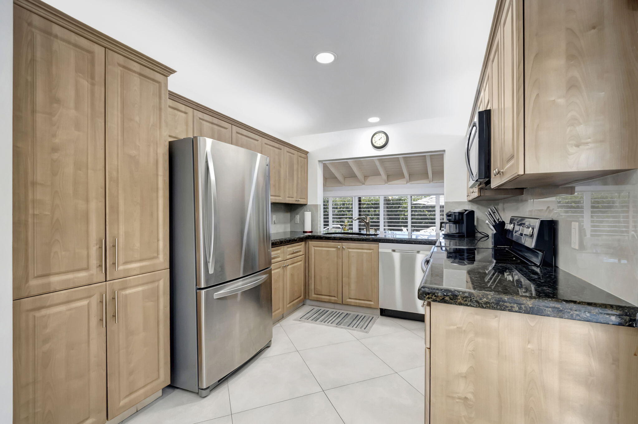 902 Foxpointe Circle Delray Beach, FL 33445 - Photo 19 of 43 a kitchen with granite countertop a refrigerator and a sink