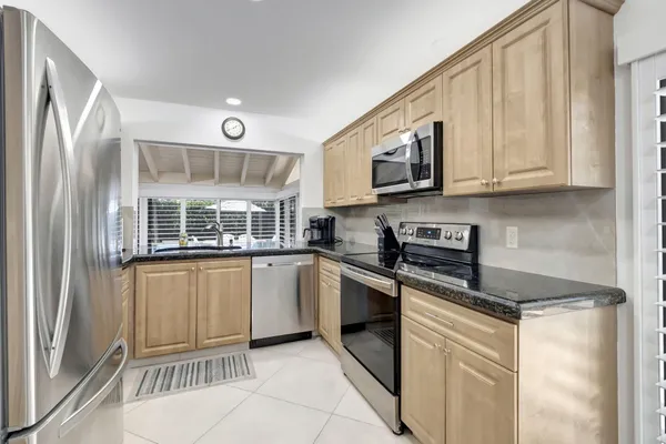 a kitchen with stainless steel appliances granite countertop a stove a sink and a microwave