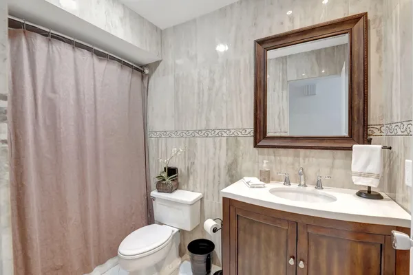 a bathroom with a toilet a sink and a mirror