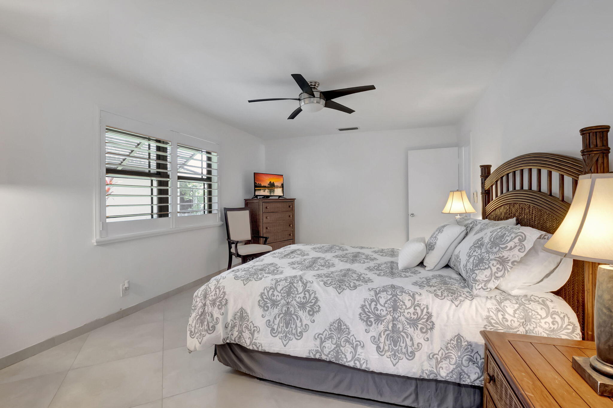 902 Foxpointe Circle Delray Beach, FL 33445 - Photo 32 of 43 a bedroom with a bed wooden floor and a window